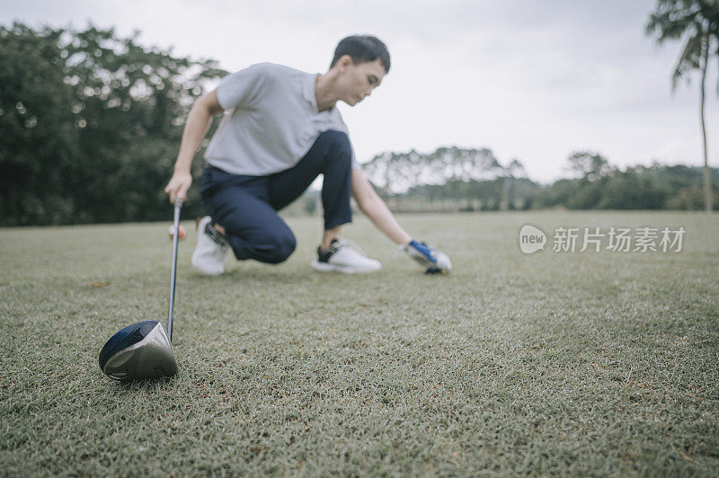 Asian chinese young couple golfer teeing off and swing his driver club on the golf course